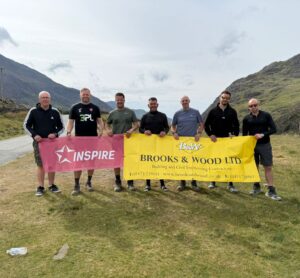 Brooks and Wood team holding banners in mountain area